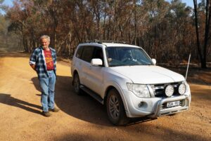 00 co-driver Peter McEwan standing beside the Barry Johnston-Graeme Vaux Pajero (Geoff Byron)